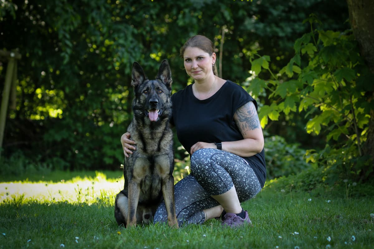 Foto von Kimberly Olszewski mit ihrem Schäferhund Ferry in einem Wald