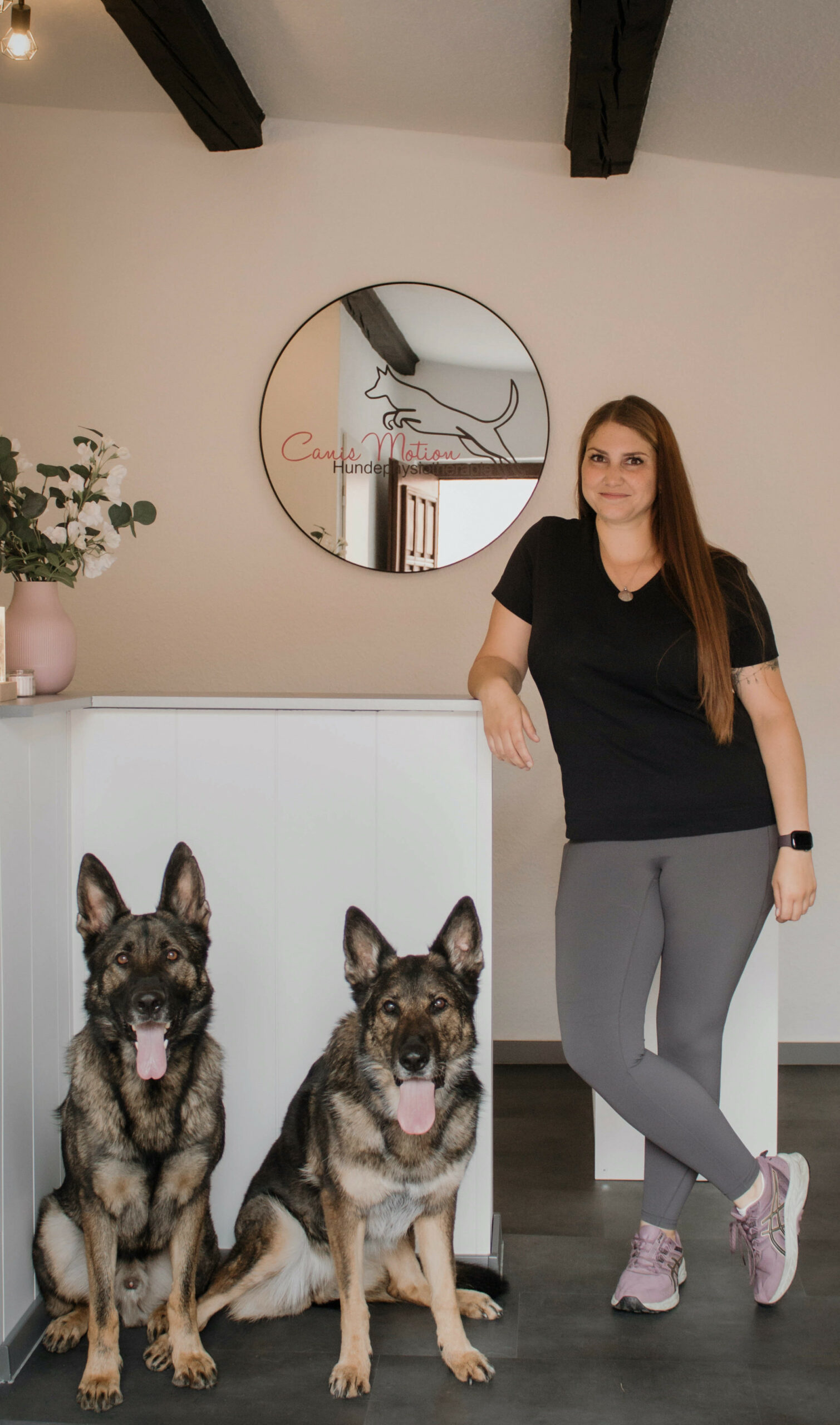 HUndephysiotherapeutin Kimberly Olszewski posiert mit Scäferhund Ferry im Wald